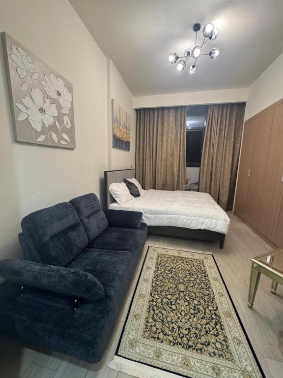 a living room with a couch and a bed at Sophisticated Studio Designer Interiors in Dubai