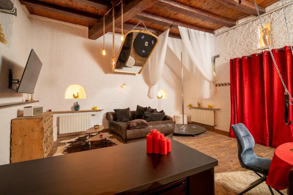 ein Wohnzimmer mit Sofa und Tisch in der Unterkunft Le Confidentiel - Le Refuge de vos Désirs secrets in Sélestat