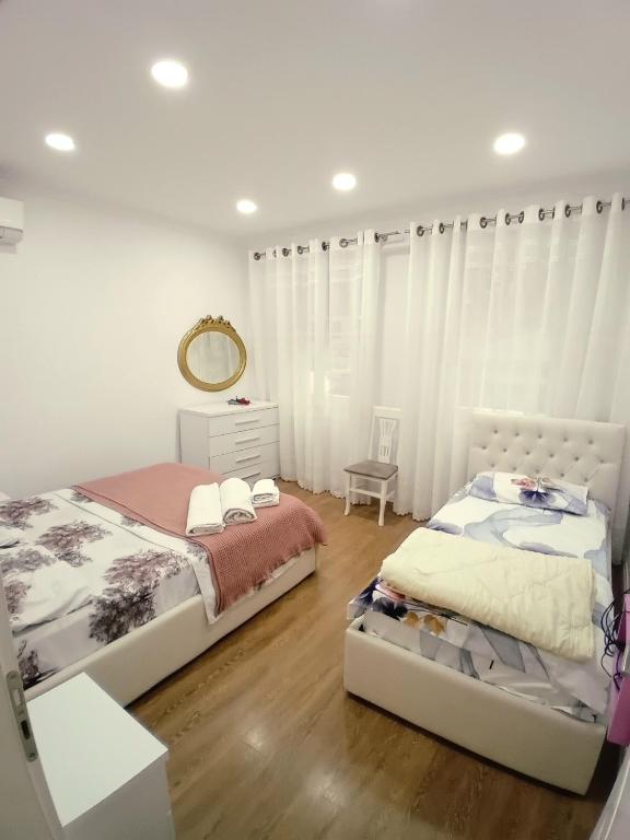 a bedroom with two beds and a mirror at Serendipity Apartment in Tirana