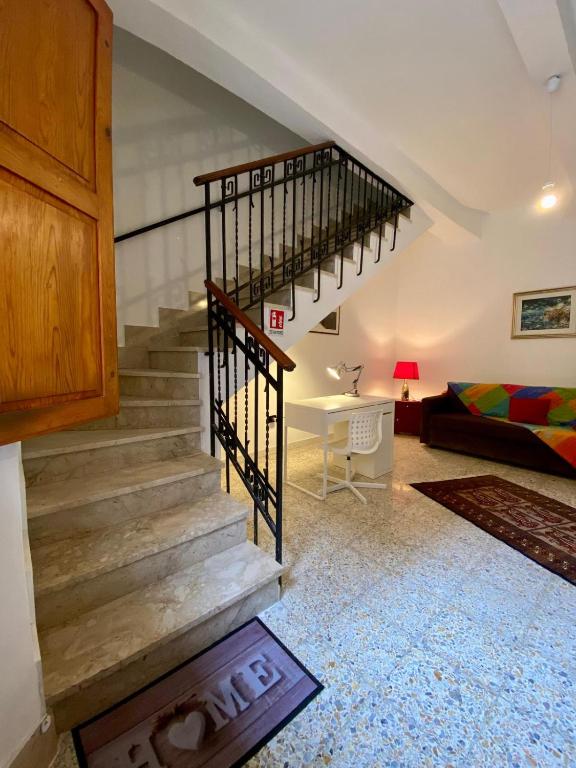 a staircase in a living room with a couch at Casa Giulia, comoda palazzina indipendente in Reggio di Calabria