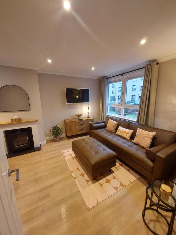 een woonkamer met een bank en een tv bij 1 Carn Dearg in Fort William