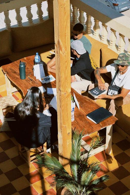 a group of people sitting around a wooden table at Muza Guest House in Tamraght Ouzdar