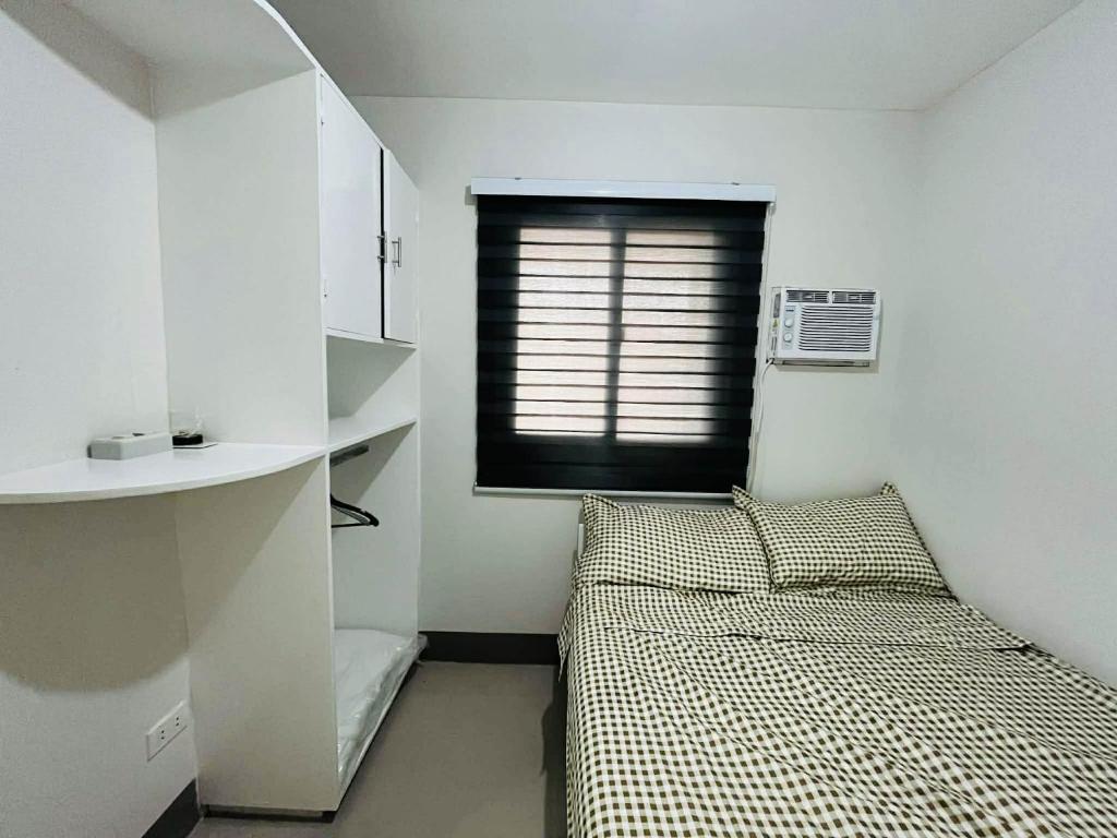 Ένα ή περισσότερα κρεβάτια σε δωμάτιο στο Nica's place at ORMOC CITY RESIDENCES DEO HOMES