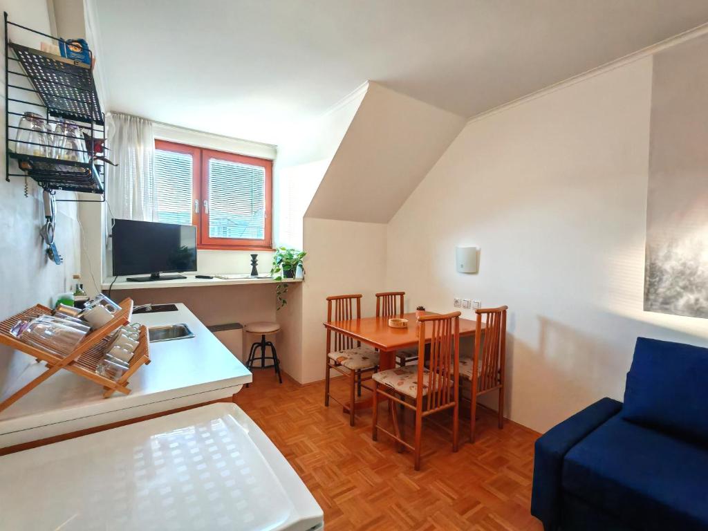 una pequeña sala de estar con una mesa y un sofá azul en Apartma Roglina, en Zreče