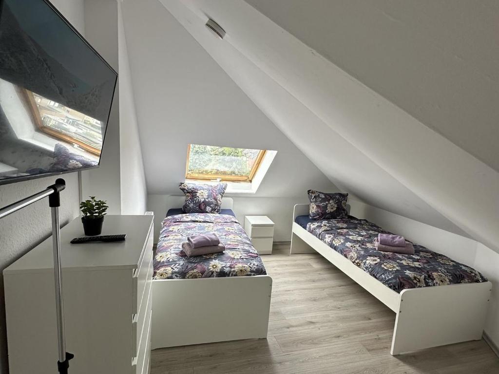a attic room with two beds and a tv at Fully equipped Apartment in Castrop-Rauxel in Castrop-Rauxel