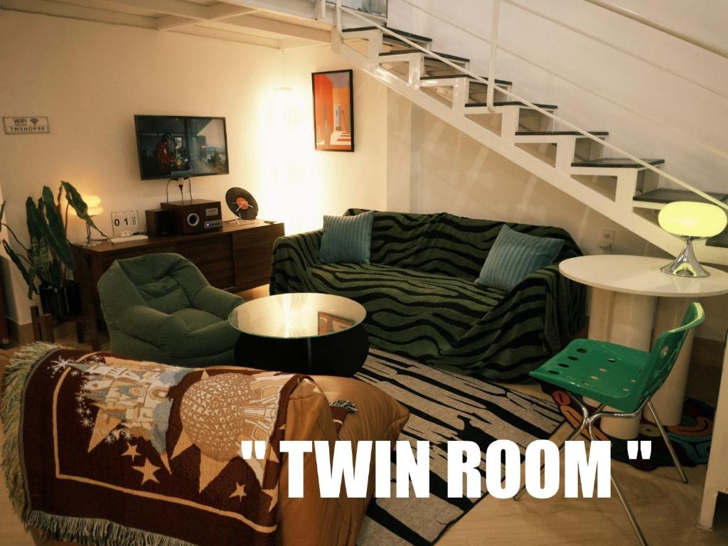 a living room with a couch and a stair case at TM Homestay Trung Tâm Phan Thiết 2 in Phan Thiet