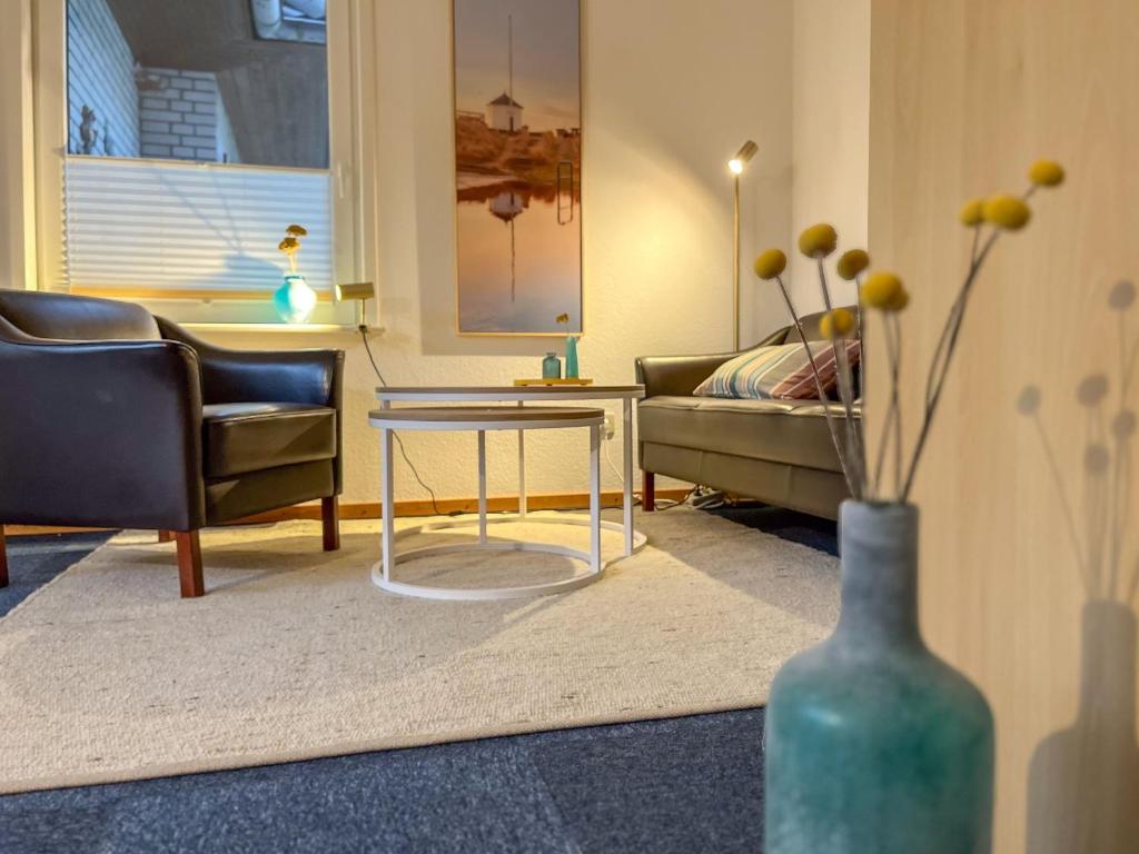 a living room with a couch and a table at Eldorado Ferienwohnungen in Norddorf