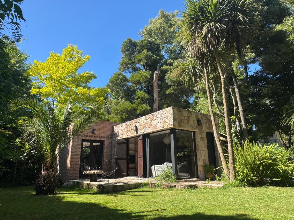 a brick house with palm trees in a yard at Ruca Tenglo in Mar del Plata