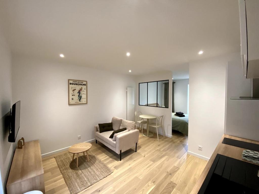 a living room with a couch and a table at Au Passage de Pommard in Pommard