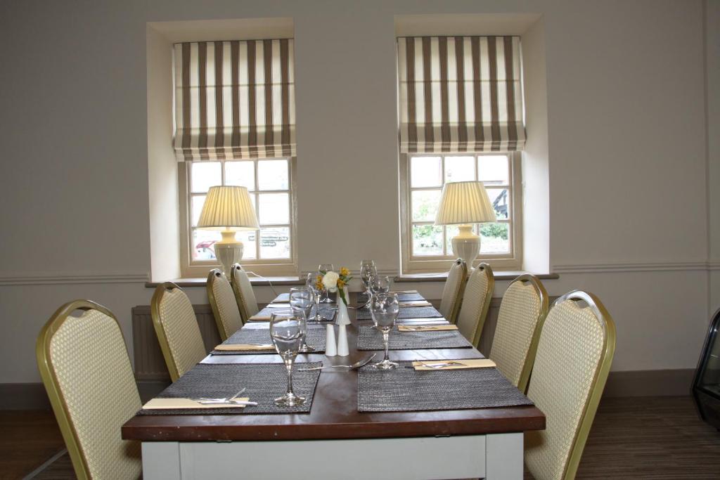 a dining room with a long table and chairs at Gwesty Nanhoron Arms Hotel in Nefyn