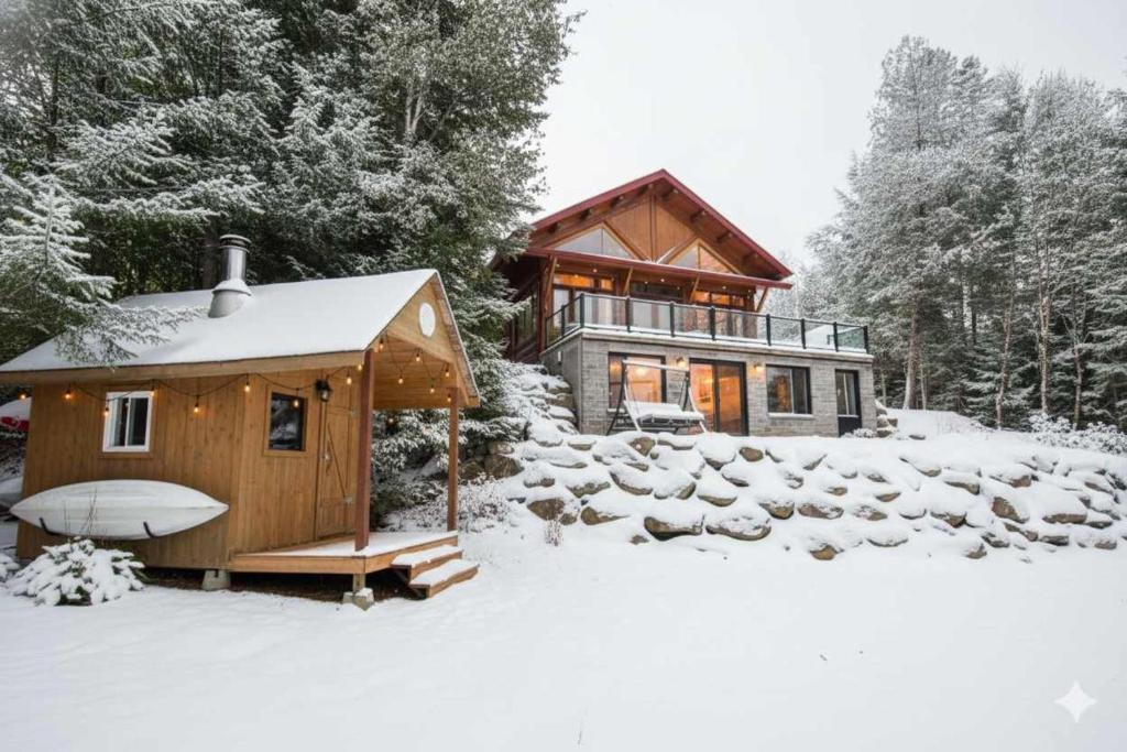una casa nella neve con una tavola da surf davanti di Log cabin - Lakeside - Le Oly a Saint Romain
