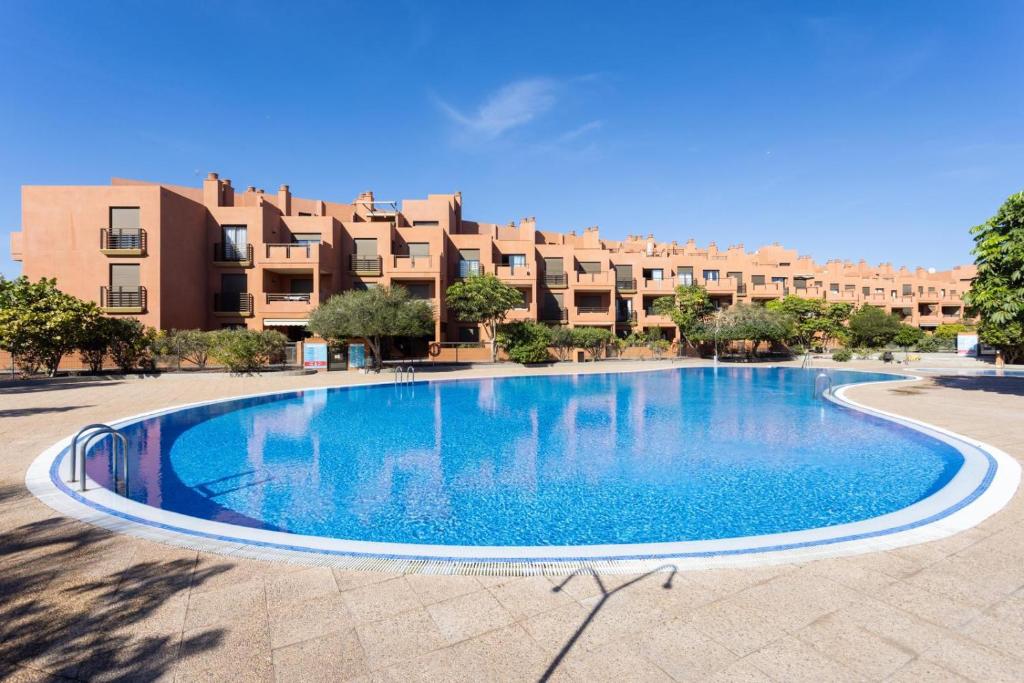 una gran piscina frente a un edificio en Apartamento Sotavento III S, en La Tejita