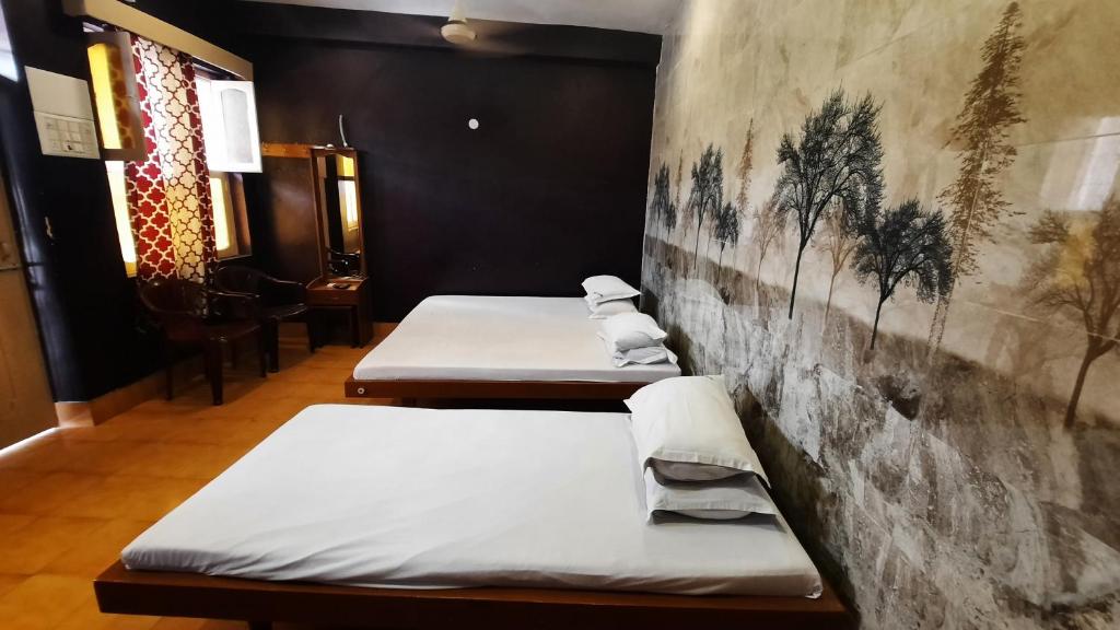 two beds are lined up against a wall at BALAN INTERNATIONAL lodging in Chennai