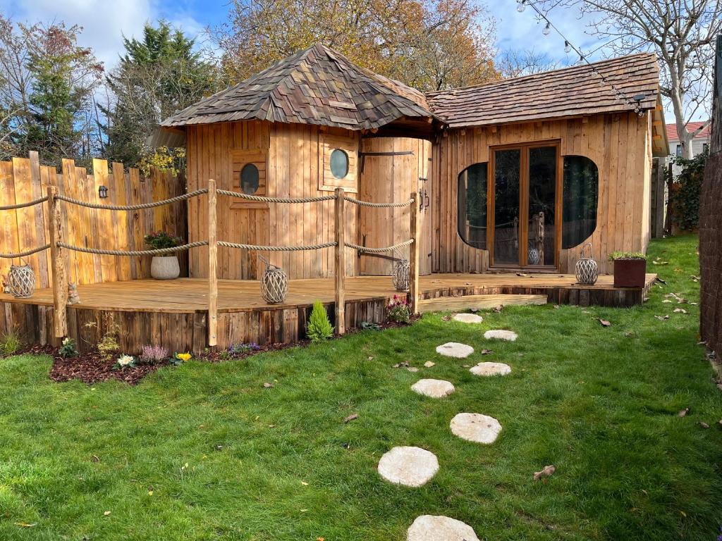 une maison en bois avec une terrasse dans une cour dans l'établissement La Belle Vie La, à Saintry-sur-Seine