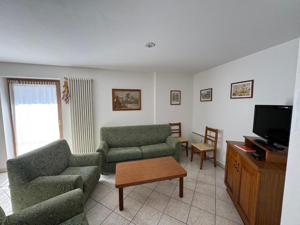 a living room with two couches and a tv at Appartamento Fontane in Panchia