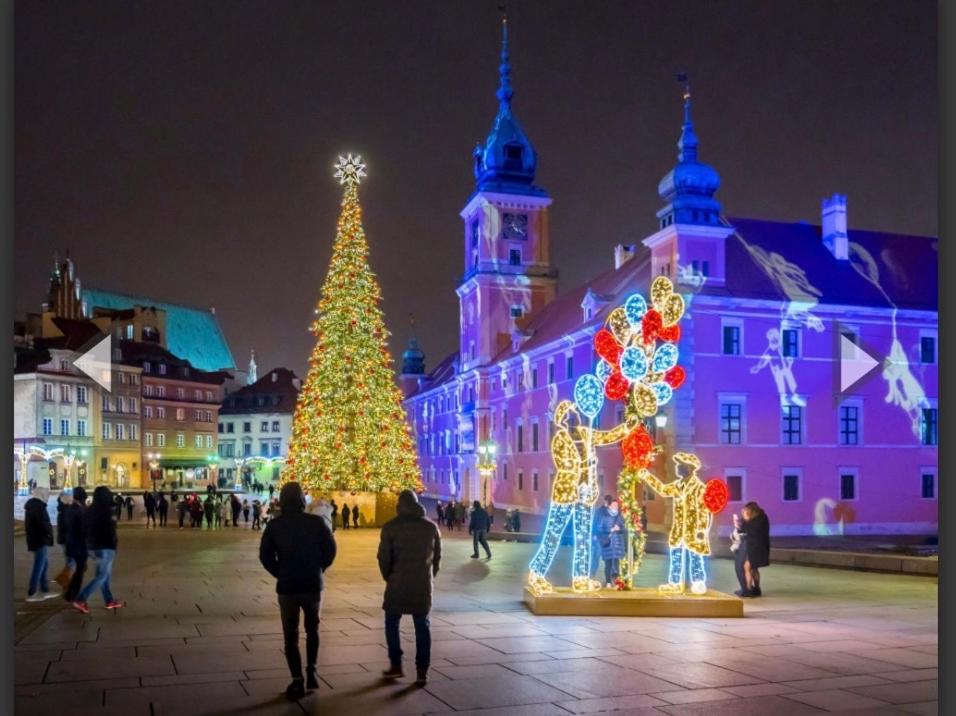 a christmas tree and people walking in front of a building at Old Town Residence, Historic Centre Castle Square in Warsaw
