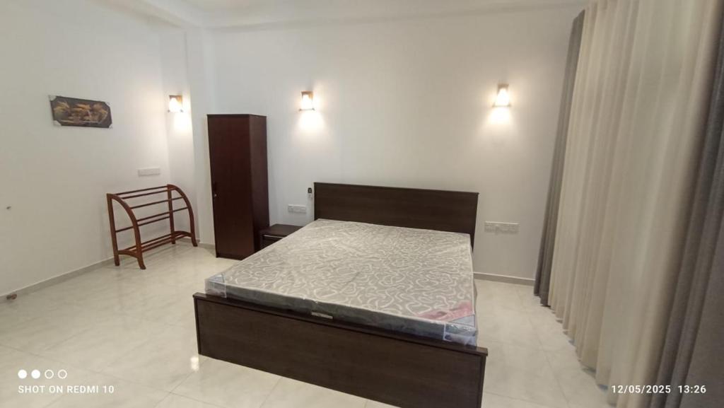 a small bedroom with a bed and a chair at Blue Sky Villa 02 Ahangama in Ahangama