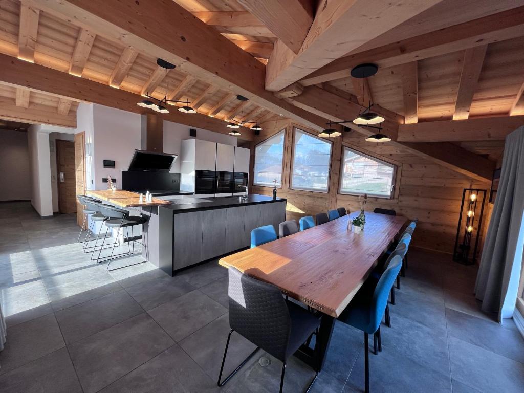 een eetkamer en een keuken met een houten tafel en stoelen bij Hameau des clos Téléporté in Les Gets