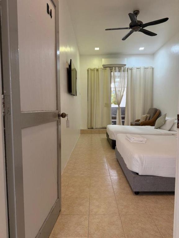 a room with two beds and a ceiling fan at Ardour Lodge "B" Wing in George Town