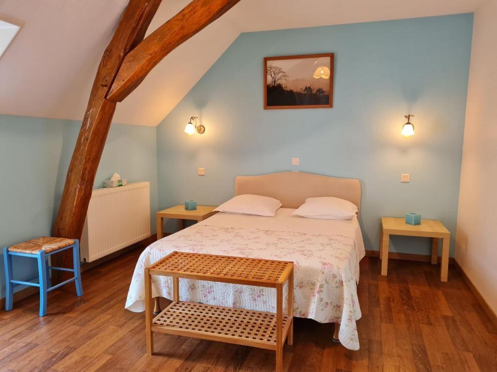 a bedroom with a bed and two tables at Chambre 1, Les Lilas in Cravant