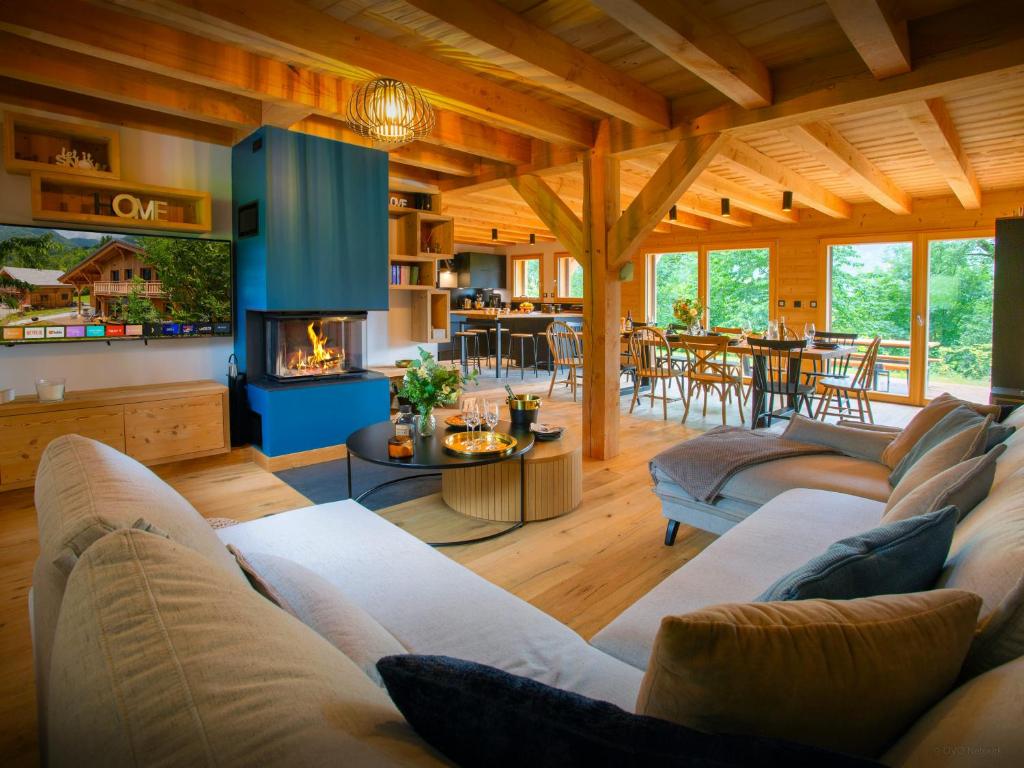 een woonkamer met banken en een open haard in een huis bij Chalet Lezopau - OVO Network in Samoëns