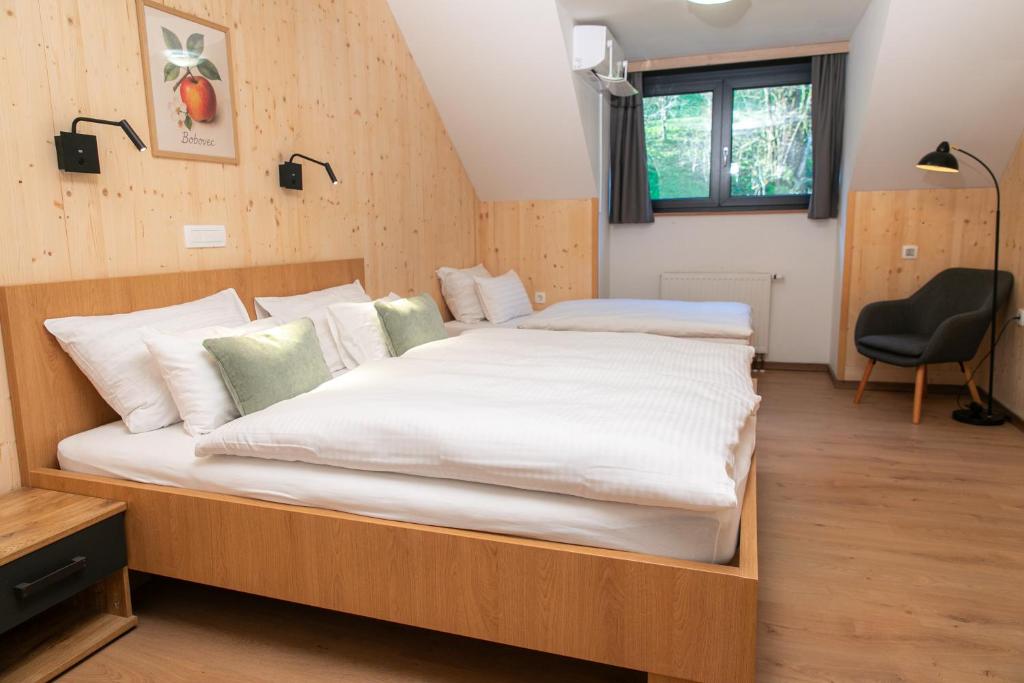 een slaapkamer met een groot bed, een bureau en een stoel bij Kozjanski dvor in Podčetrtek