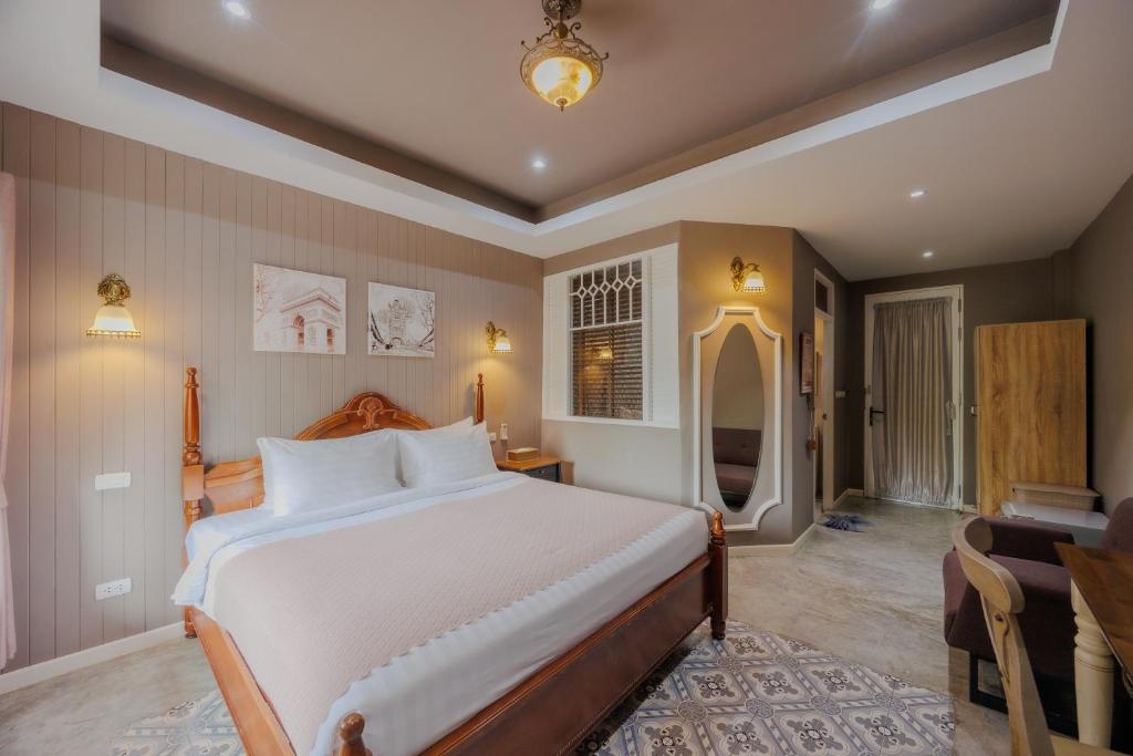 a bedroom with a large bed and a desk at Perennial Resort in Nai Yang Beach