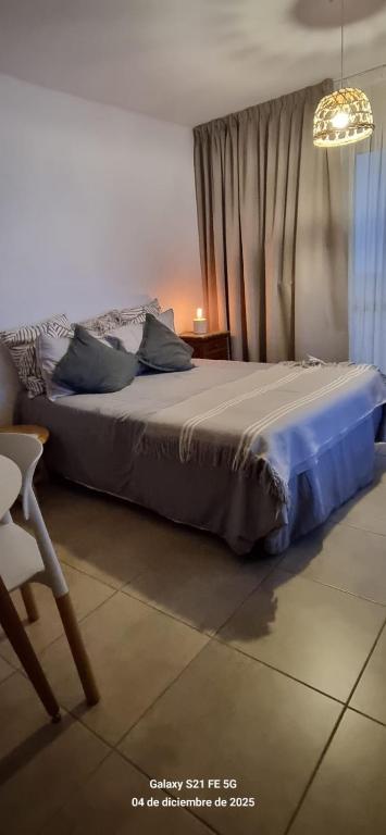 a bedroom with a bed and a chair and a chandelier at La Nona Nidia in Paraná