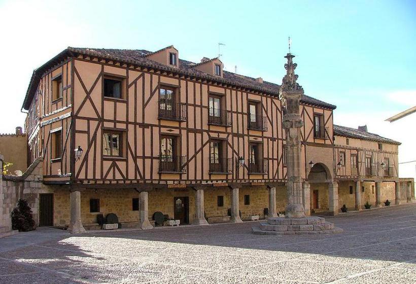 Un gran edificio con una cruz en la parte superior. en Posada Restaurante Ducal, en Peñaranda de Duero