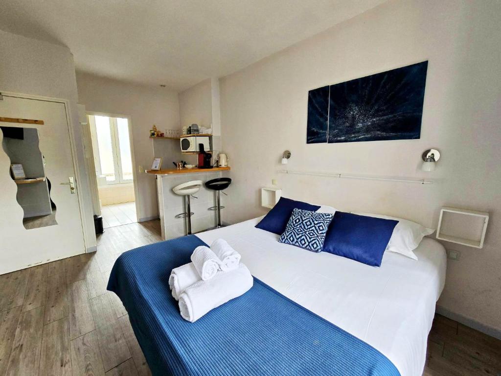 una camera da letto con un letto grande con asciugamani sopra di LAYTON - A 2 min de la plage, du sillon et d'Intra muros ! a Saint Malo