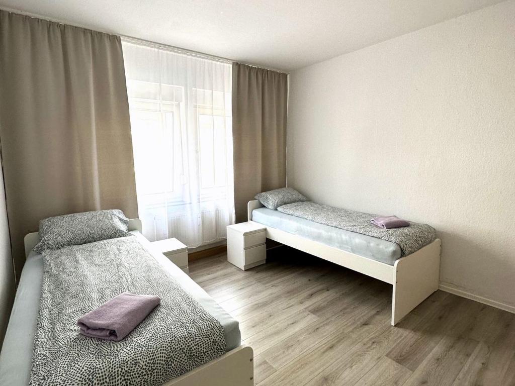 a small room with two beds and a window at Gemütliche Apartments in Herten in Herten