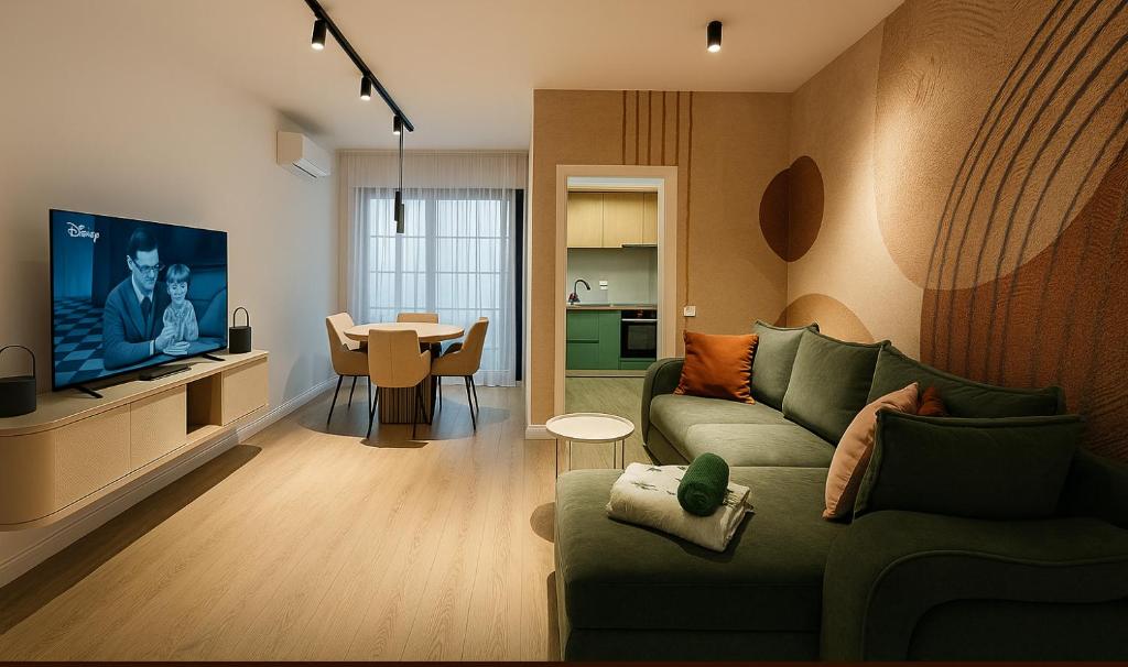 een woonkamer met een groene bank en een tafel bij Smart Serendipity Apartments in Boekarest