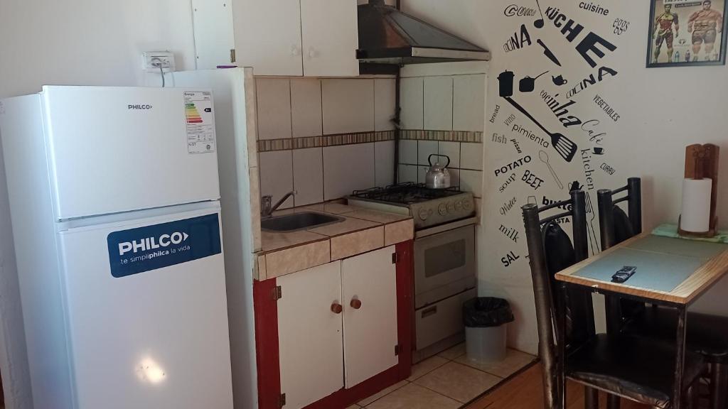 a kitchen with a white refrigerator and a sink at Departamento 1 in Comodoro Rivadavia