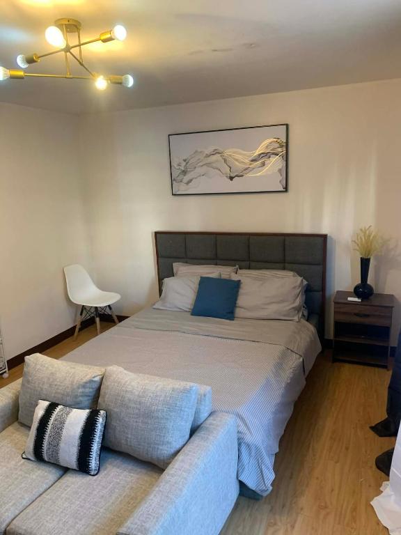a bedroom with a large bed and a couch at 1 Bedroom Arezzo Condotel in Davao City