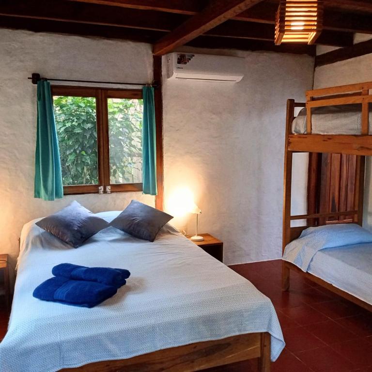 a bedroom with a bed with two bunk beds at Las Cabañas de la Iguana in Ayampe