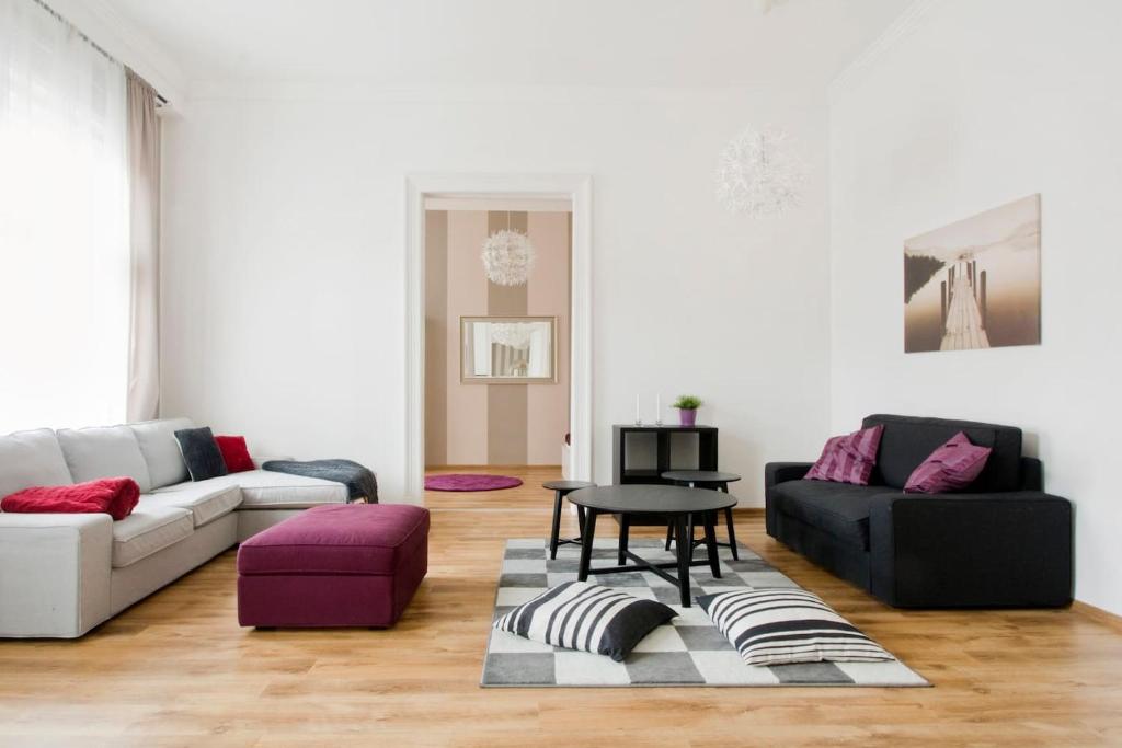 a living room with two couches and a table at Downtown Rising Sun 104 sq.m in Budapest