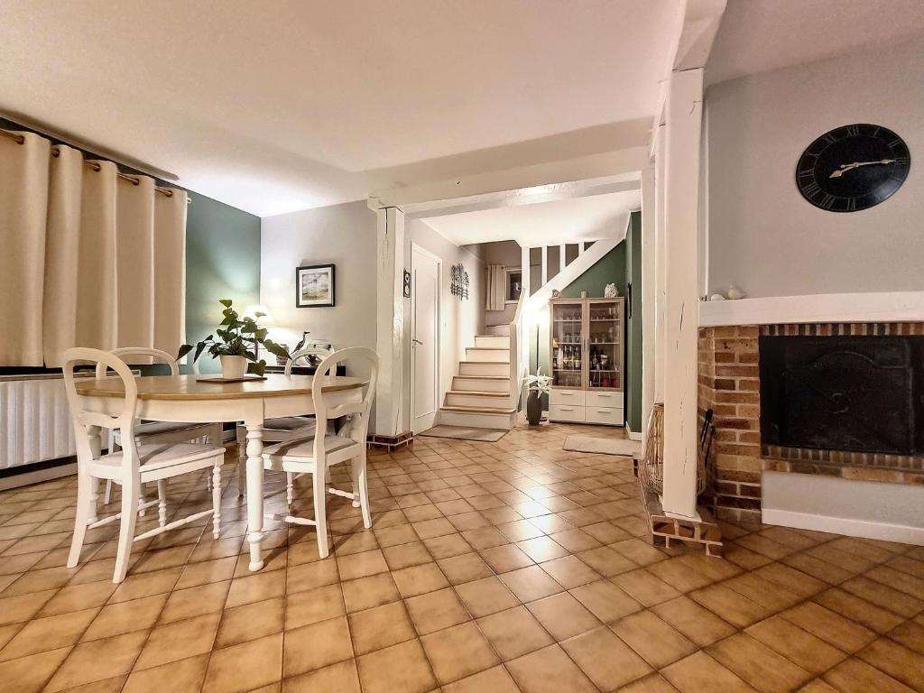 "Chambre familiale", La Maison des Grenouilles في Férolles: غرفة طعام مع طاولة وكراسي ومدفأة
