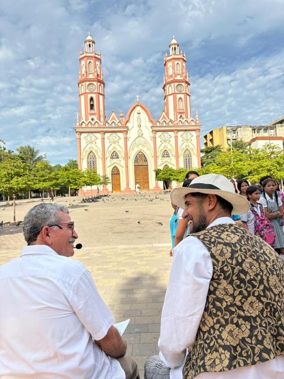 a group of men sitting in front of a church at hotel san nicolas colonial in Barranquilla