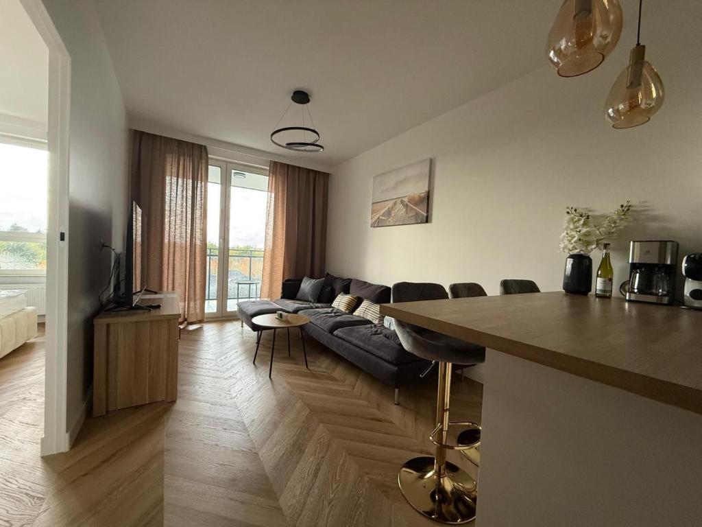 a living room with a couch and a table at Jarzebinowa Loft III by JumpInHere in Nowy Dwór Mazowiecki