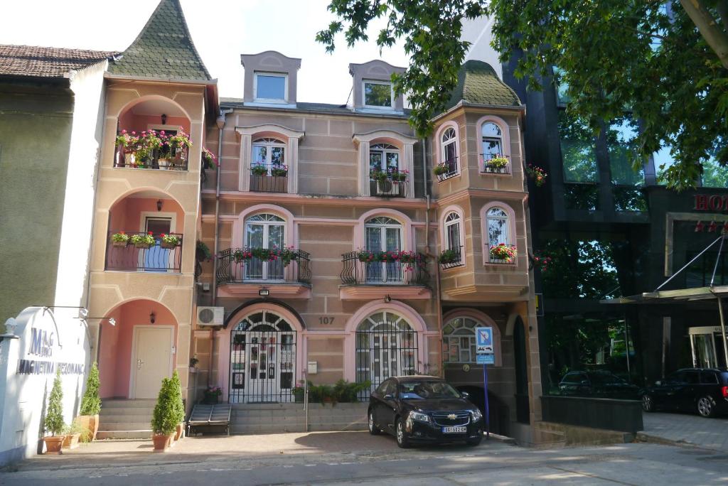 un edificio con un coche aparcado delante de él en Guest House Villa Lord en Novi Sad