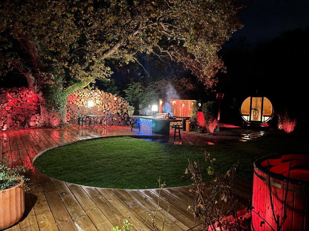 a garden at night with a table and a tree at Acorn Hideaway in Canterbury