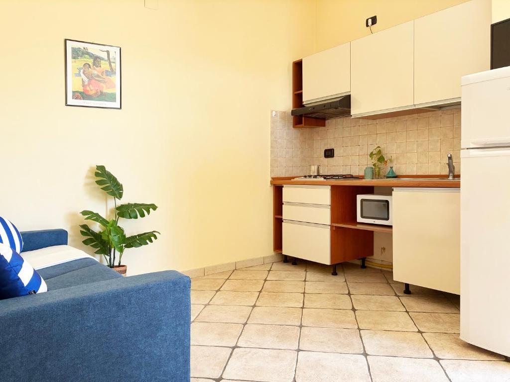 een keuken met een blauwe bank in een kamer bij Holihome Vascello A7 in Tortoreto Lido