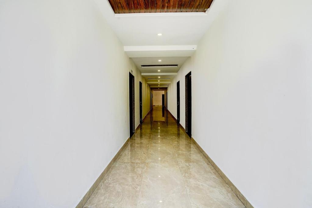 Hotel O SR Farm في Bodakdev: ممر فارغ بجدران بيضاء وسقف