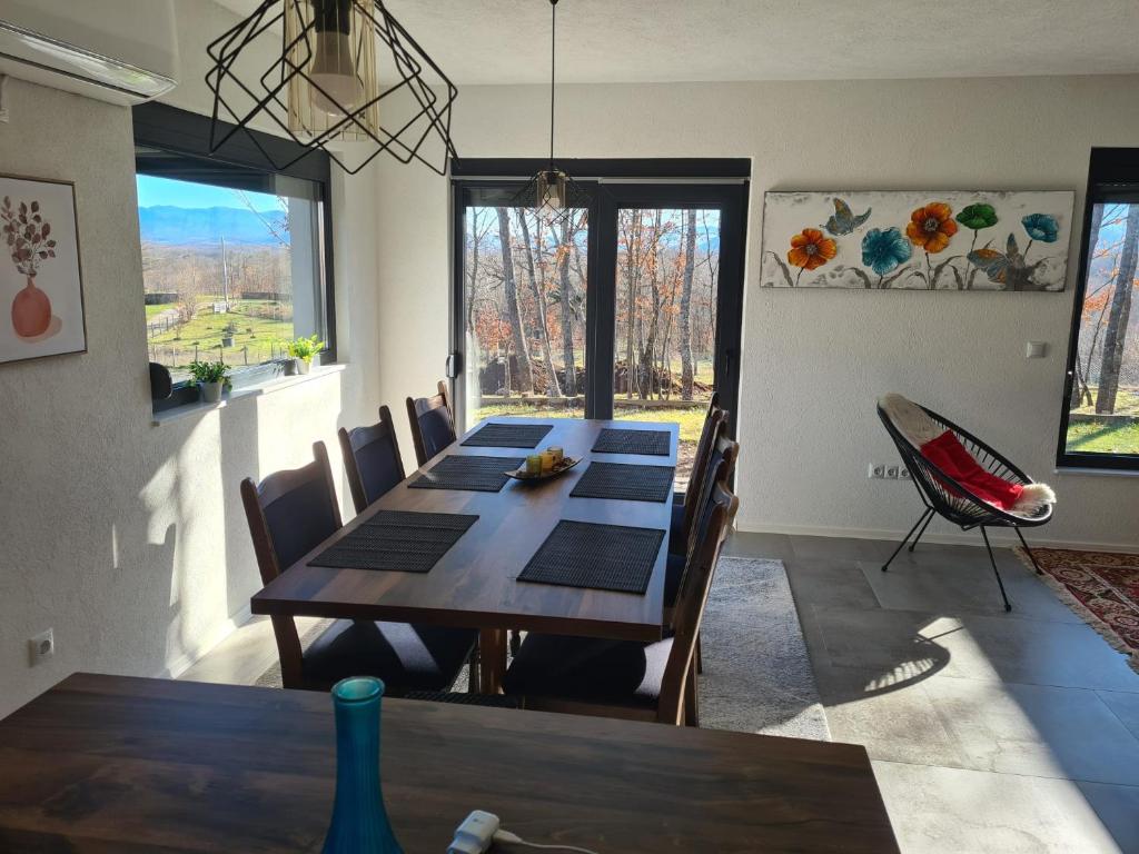 Villa Aria في Bosanska Krupa: غرفة طعام مع طاولة وكراسي خشبية