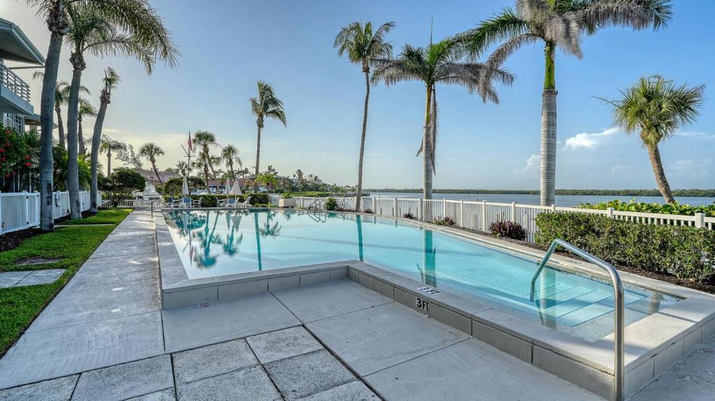 een zwembad met palmbomen en de oceaan bij Waterfront, Spa/Pool, Private Paradise On LBK! in Longboat Key