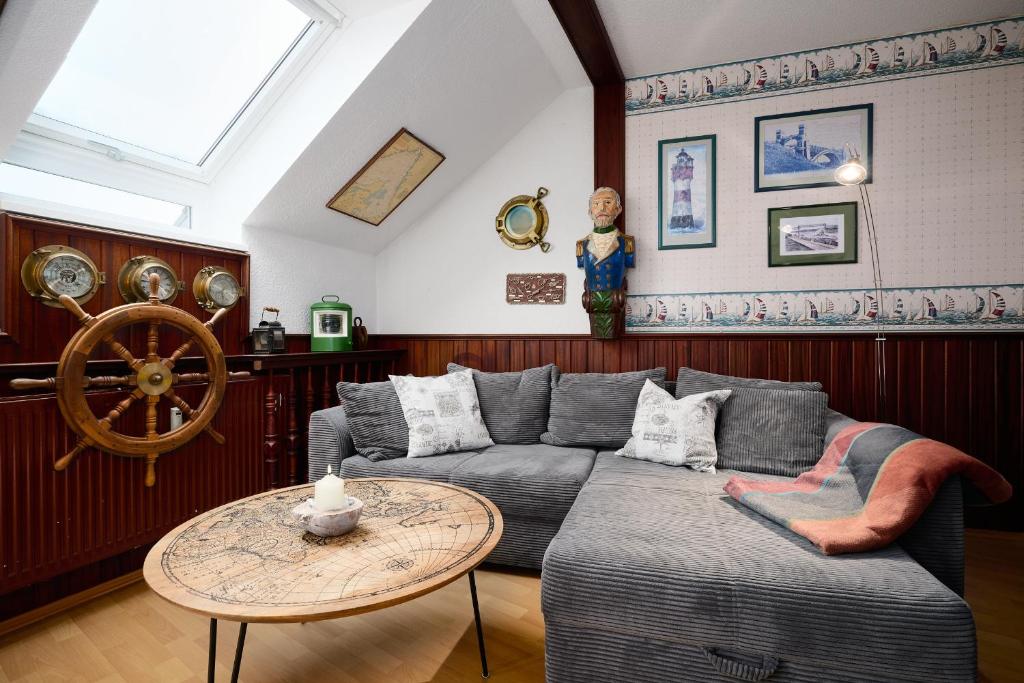 een woonkamer met een bank en een tafel bij Deichweg 33 Käptns Kajüte in Kalifornien