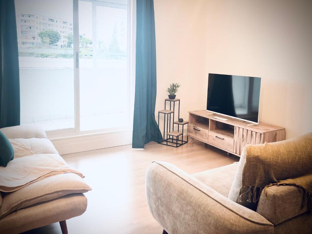 a living room with a television and a couch at La Varangue bleu T3 Aéroport Sainte Marie in Sainte-Marie