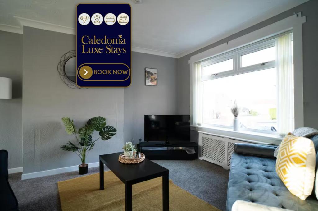 a living room with a blue couch and a table at Darmeid House in Kirk of Shotts