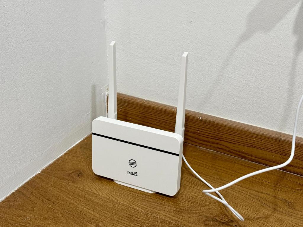 a white router sitting on a wooden floor next to a wall at Make Memories Escape 2BR Stay Summer Mall in Kota Samarahan