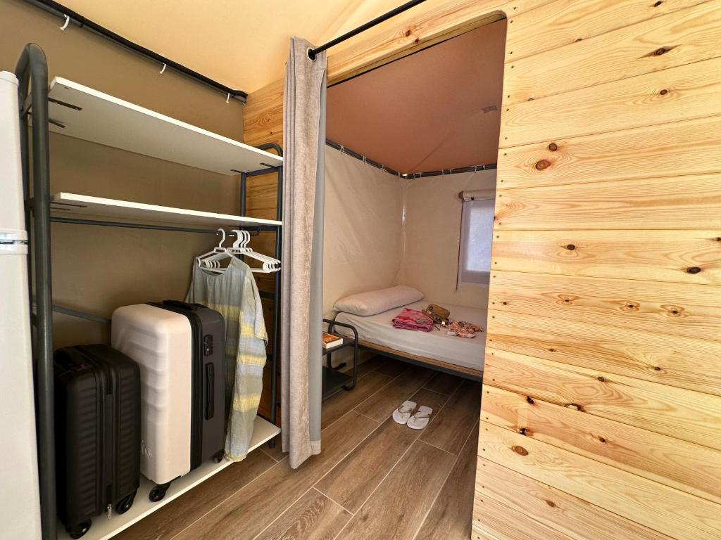 ein Zimmer mit einem Schrank mit Gepäck und einem Bett in der Unterkunft Tienda Guara in Alquézar